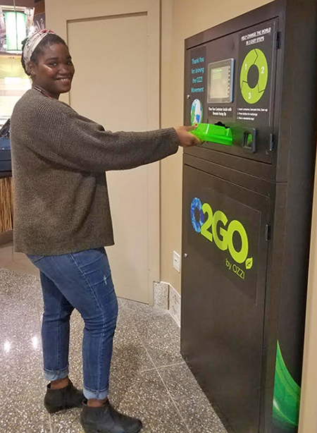 Photo of student loading O2GO container into the OZZI machine