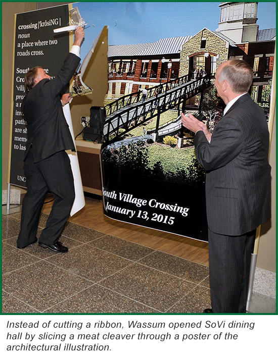 Photo: Instead of cutting a ribbon, Wassum opened SoVi dining hall by slicing a meat cleaver through a poster of the architectural illustration. 