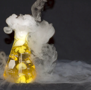 photo of "potion" chemical reaction  - smoke pouring from a beaker with yellow fluid